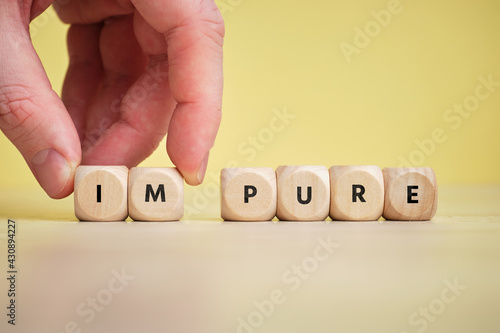 Concept pure and impure on wooden cubes.
