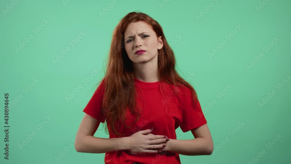 Woman squeezing belly with hands because of abdominal pain. Lady suffering from stomach ache. Healthcare, problem with menstrual period cramps or bowel flatulence concept Woman squeezing belly with hands because of abdominal pain. Lady suffering from stomach ache. Healthcare, problem with menstrual period cramps or bowel flatulence concept