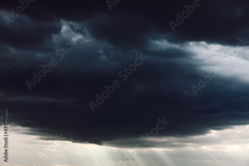 Black clouds with sun rays . Stormy weather with cloudburst