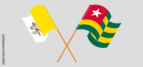 Crossed and waving flags of Vatican and Togo