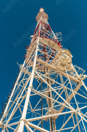 Vertical shot of the Lviv TV Tower against a clear blue sky background photo