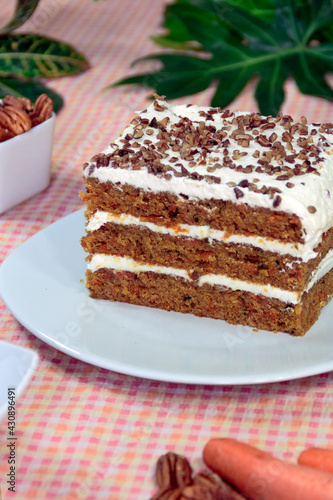 Slice of homemade carrot cake with cream and nuts. 