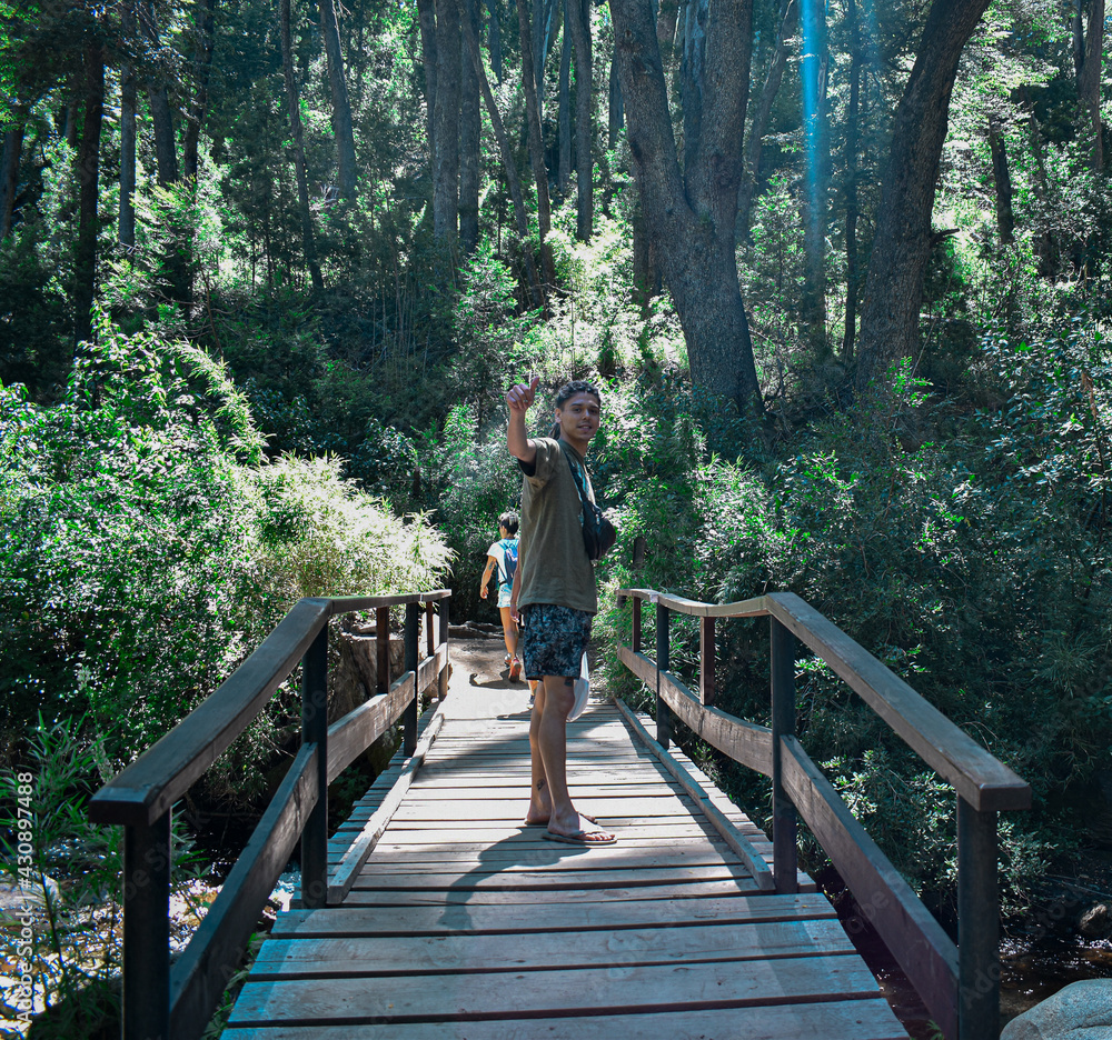 hombre joven caminando por un puente dentro del bosque hombre joven caminando por un puente dentro del bosque