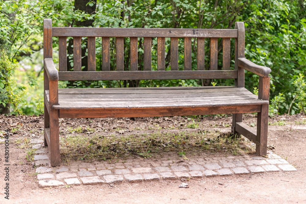 Old wooden bench. Cozy bench in a green corner near the path. A bench under the walls of the castle of Brno in the Czech Republic. Old wooden bench. Cozy bench in a green corner near the path. A bench under the walls of the castle of Brno in the Czech Republic.
