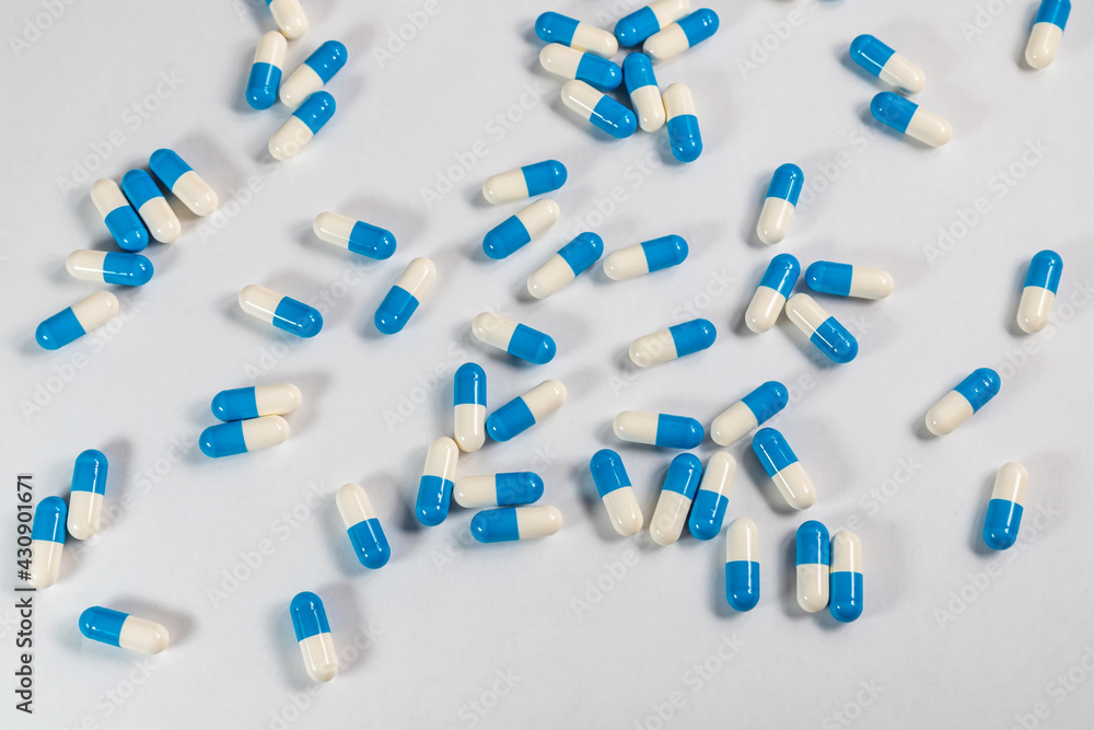 blue tablets capsules on a light gray or white background
