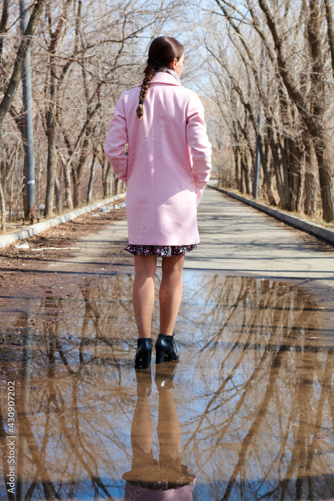 one girl stands in a puddle with a reflection of trees one girl stands in a puddle with a reflection of trees