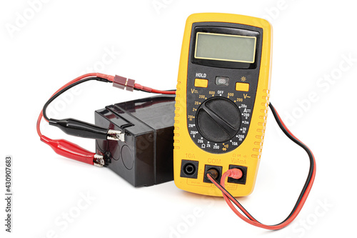 Testing an acid rechargeable battery with a measuring instrument isolated on white background