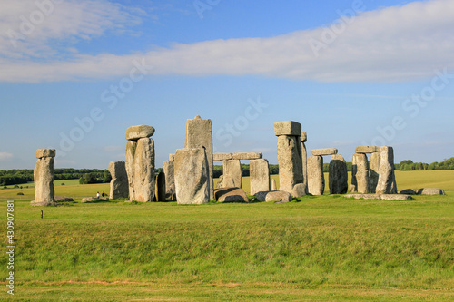 Stonehenge in the late afternoon with blue sky and green grass 