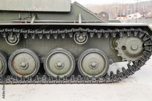 Tank of the Second World War. Track armor close-up. Black track link and large rubberized rollers. Tank chassis. The tank stands on a pedestal.Russia, May 9, 2021. Detail of a tracked tank close-up. photo