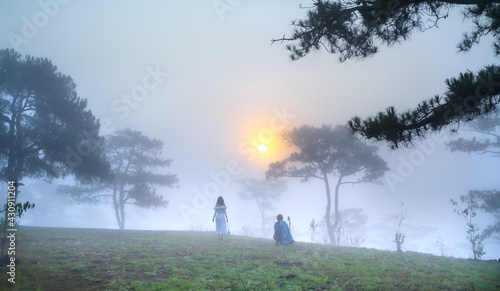 Fototapeta Naklejka Na Ścianę i Meble -  Tourists watching the dawn on a misty morning pine hill on the top of the highlands of Da Lat, Vietnam