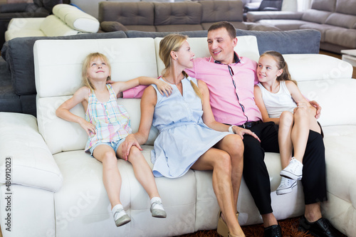 Parents with kids is pleased by new sofa in furniture store