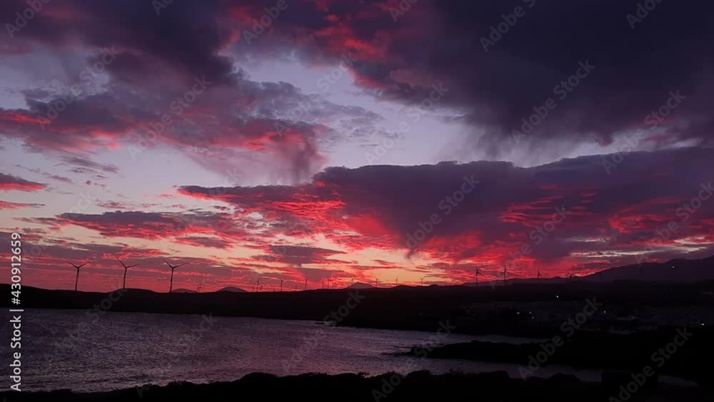 Time lapse of a colorful red sunset in Tenerife. With a windfarm in the background on a windy day. Time lapse of a colorful red sunset in Tenerife. With a windfarm in the background on a windy day.