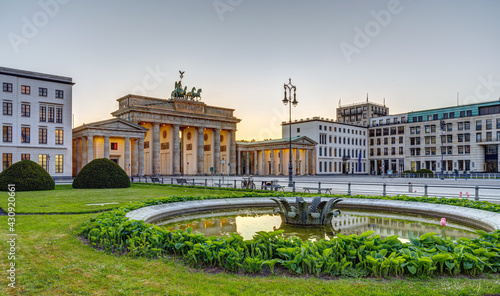 The famous Brandenburg Gate in Berlin after sunset with a fountain