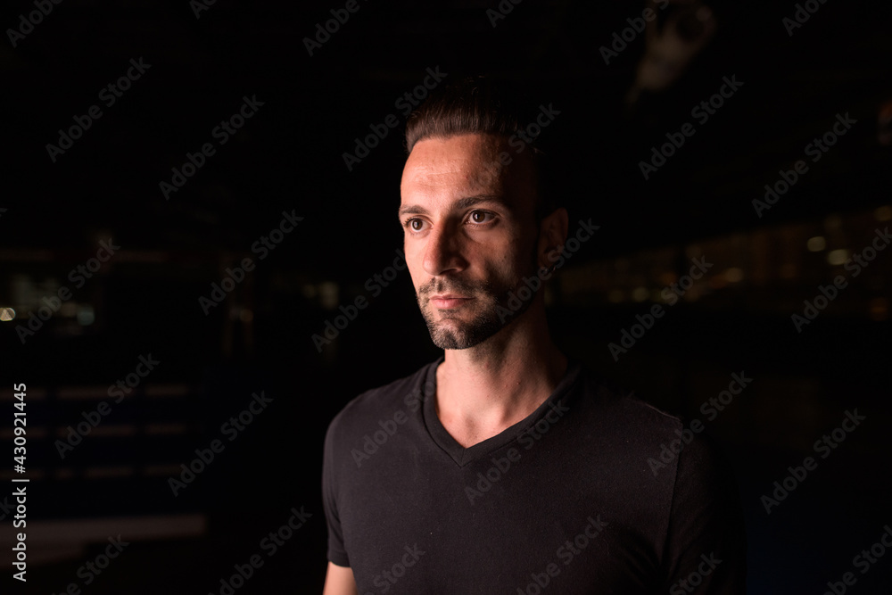 Fototapeta premium Portrait of handsome man thinking at night in parking lot building