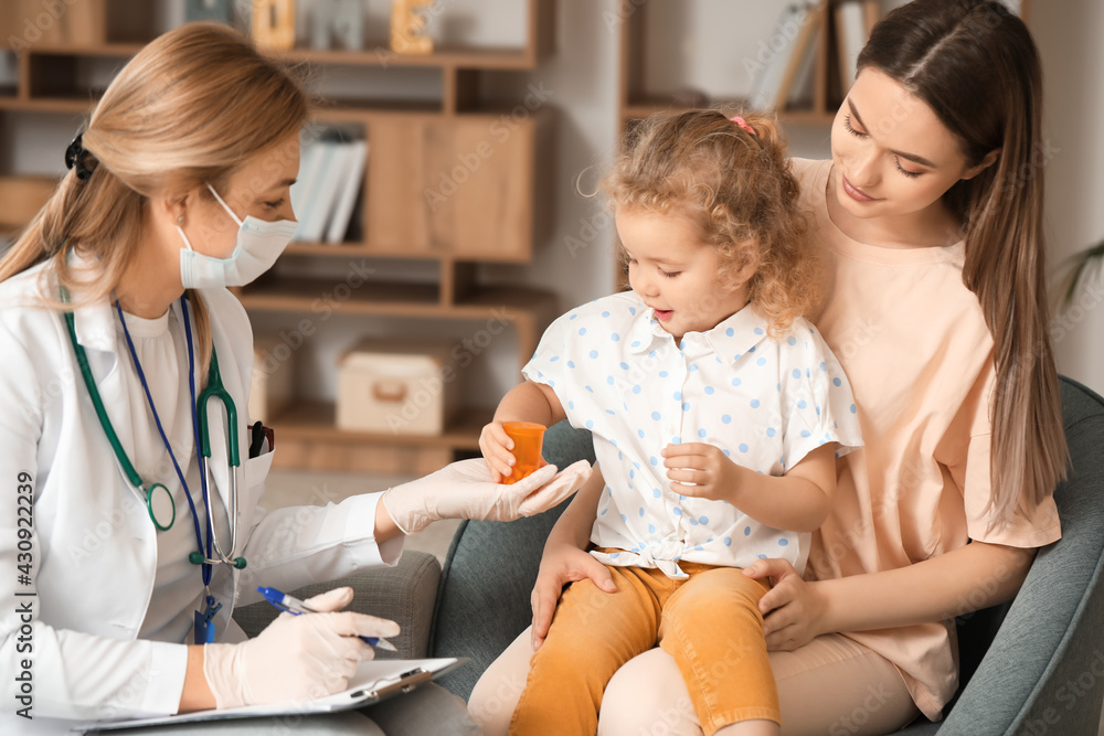 Pediatrician giving medicine to little girl at home Pediatrician giving medicine to little girl at home