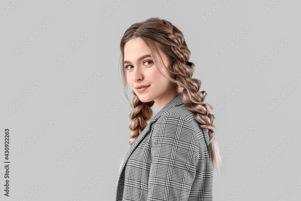 Beautiful young woman with braided hair on grey background Beautiful young woman with braided hair on grey background