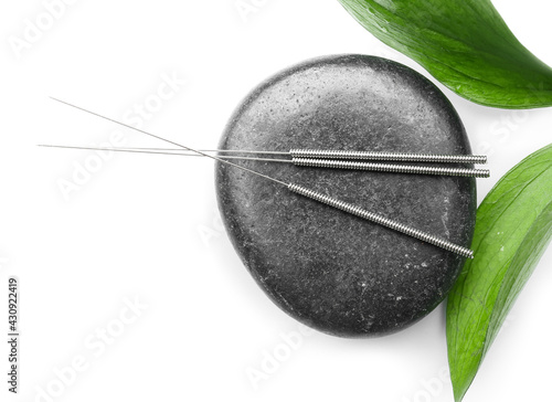 Bild auf Leinwand Acupuncture needles and spa stone on white background