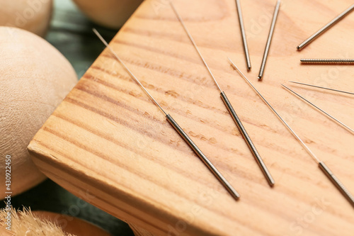 Acupuncture needles on wooden board, closeup
