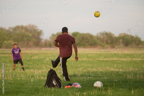 man practicing kicking soccer ball in play grass field wapato washington yakima county photo