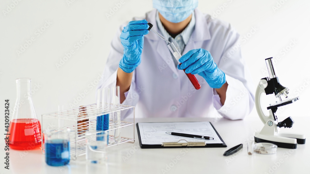 Young Asian scientist Working looking through a microscope doing research for analyzing a Experiments sample in a forensic laboratory. Young Asian scientist Working looking through a microscope doing research for analyzing a Experiments sample in a forensic laboratory.