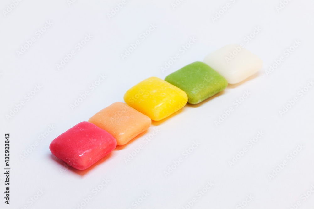 chewy candy in the colors of the rainbow on a white background chewy candy in the colors of the rainbow on a white background