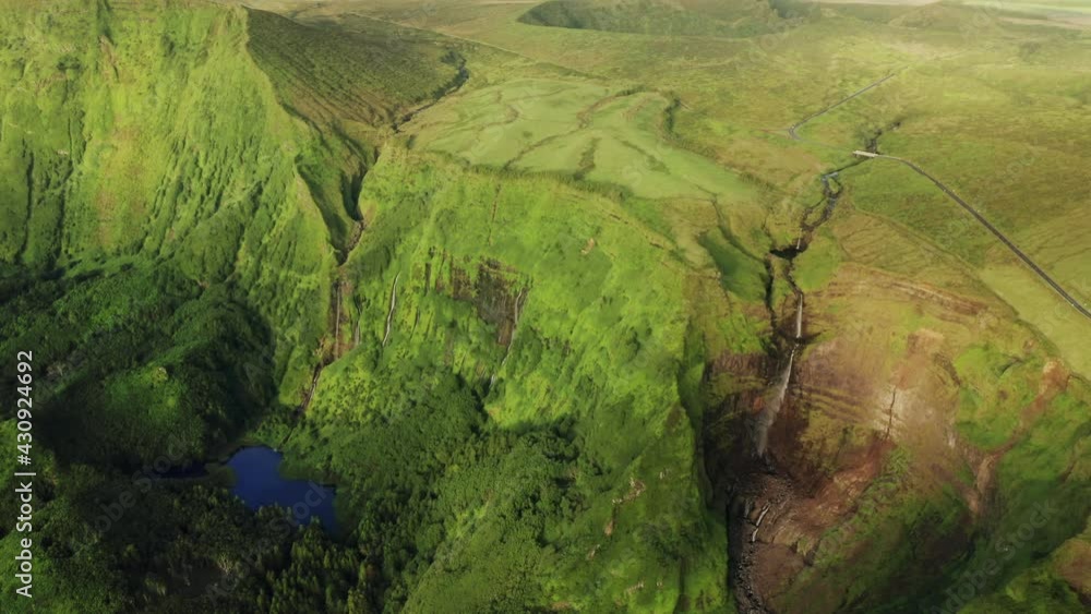 Overhead shot of mountains covered green grass in Poco Ribeira do Ferreiro, Alagoinha, Flores Island, Azores, Portugal, Europe. Amazing view of valley with waterfall and lake, 4k footage Overhead shot of mountains covered green grass in Poco Ribeira do Ferreiro, Alagoinha, Flores Island, Azores, Portugal, Europe. Amazing view of valley with waterfall and lake, 4k footage