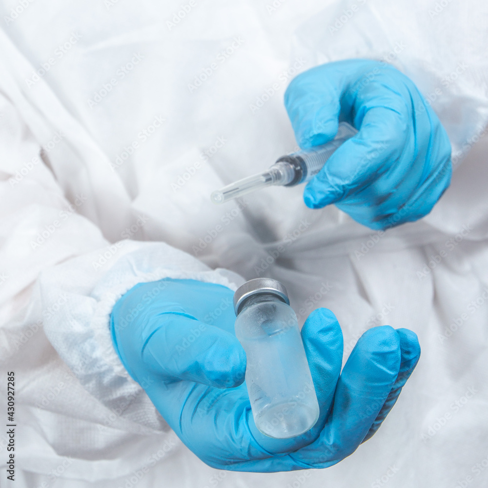 covid-19 sars-cov-2 vaccination: a health worker with a vaccine and a syringe in his hands covid-19 sars-cov-2 vaccination: a health worker with a vaccine and a syringe in his hands