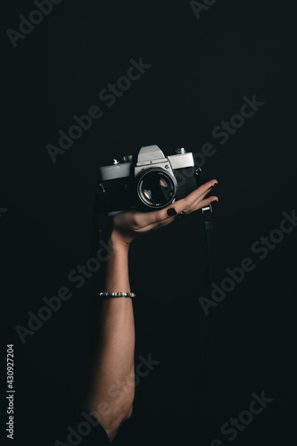 Woman's hand holding a film camera in studio