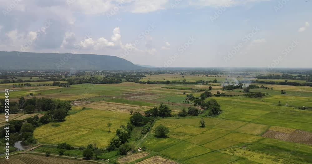Aerial drone shot panoramic view, flying forward fresh green rice fields mountain blue clouds sky on background. Aerial drone shot panoramic view, flying forward fresh green rice fields mountain blue clouds sky on background.