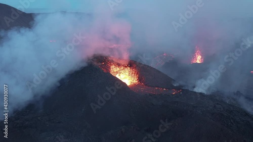 Lava gets ejected from spatter cone with clouds of toxic smoke in Iceland photo