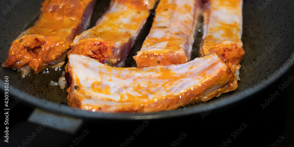 Pork ribs meat close-up in a frying pan