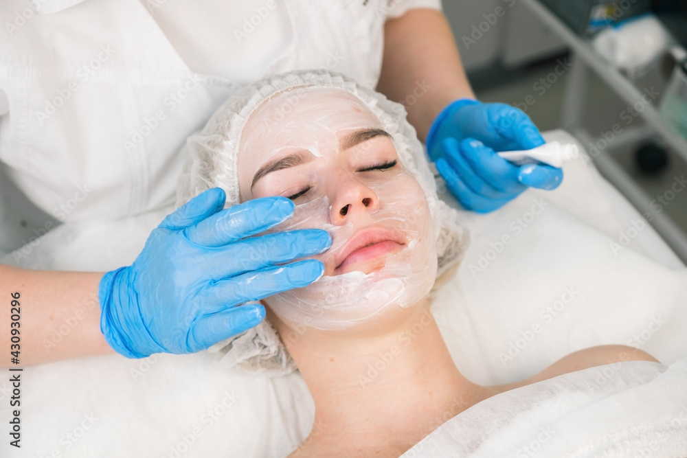 Treatment, cure of face skin in cosmetology clinic. Beauty procedure with problem skin for young woman. Cosmetologist doctor is applying cream with anesthesia before PRP therapy procedure. Treatment, cure of face skin in cosmetology clinic. Beauty procedure with problem skin for young woman. Cosmetologist doctor is applying cream with anesthesia before PRP therapy procedure.