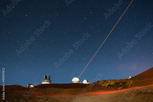 Laser light aiming to cosmos from Mauna Kea observatory during the night,  Big Island, Hawaii photo