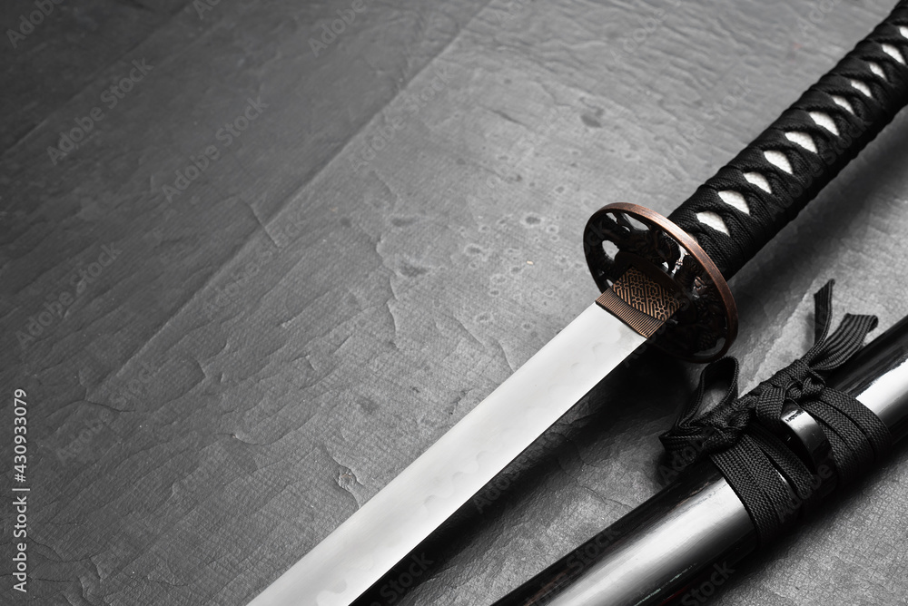 Katana sword on the black table background with copy space. Katana sword on the black table background with copy space.