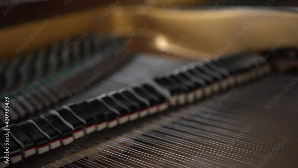 View inside a beautiful brown Grand Piano, hammers and strings moving as pianist plays classical music View inside a beautiful brown Grand Piano, hammers and strings moving as pianist plays classical music