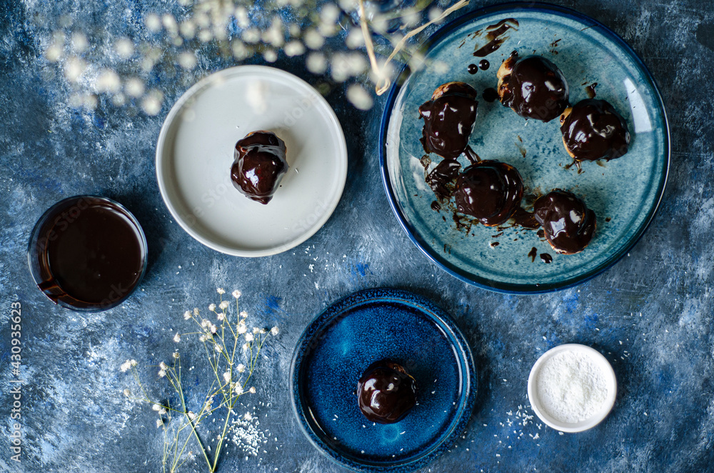 Profiterole, powdered sugar on a blue background Profiterole, powdered sugar on a blue background