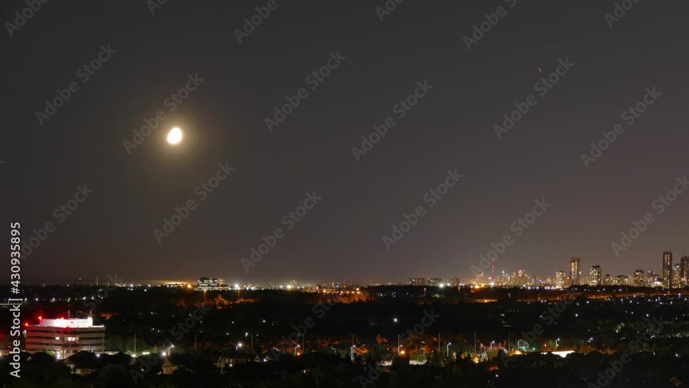 Moon moving across sky over Toronto city at night. Static time lapse Moon moving across sky over Toronto city at night. Static time lapse