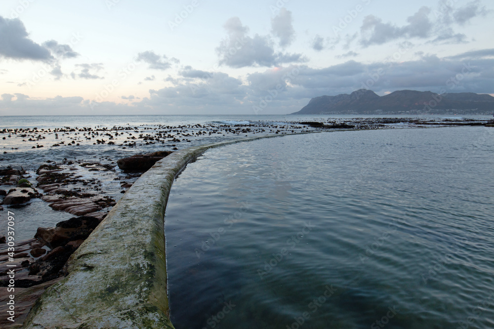 Sunrise over circular seawall at Dale Brook Tide Pool in Cape Town South Africa RSA