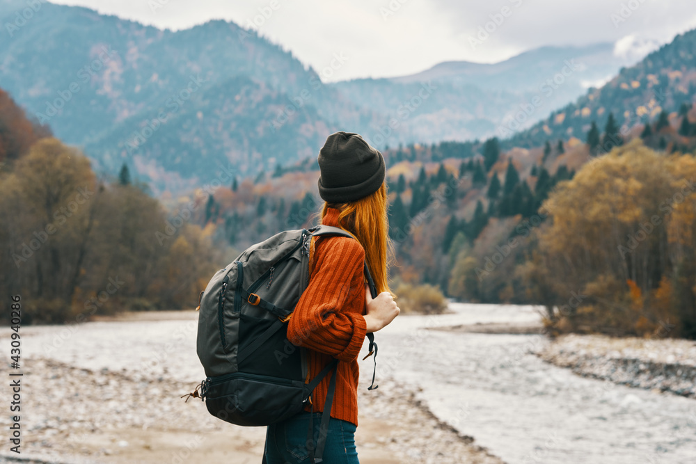 woman hiker with a backpack rest in the mountains in nature near the river woman hiker with a backpack rest in the mountains in nature near the river