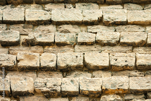 Old building stones laid in even rows forming a wall. Close-up background. photo