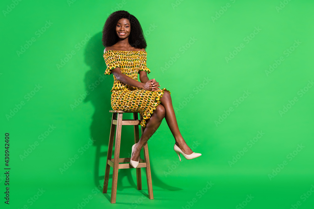 Full size photo of adorable positive dark skin girl beaming smile look camera isolated on green color background