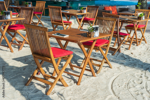 Wooden table and chairs in empty beach cafe next to sea. Close up, Thailand © OlegD