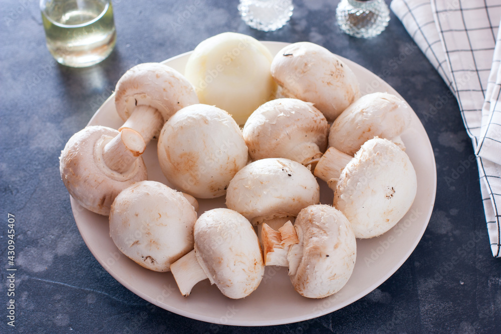 raw mushrooms on a white plate, ingredients for cooking, horizontal