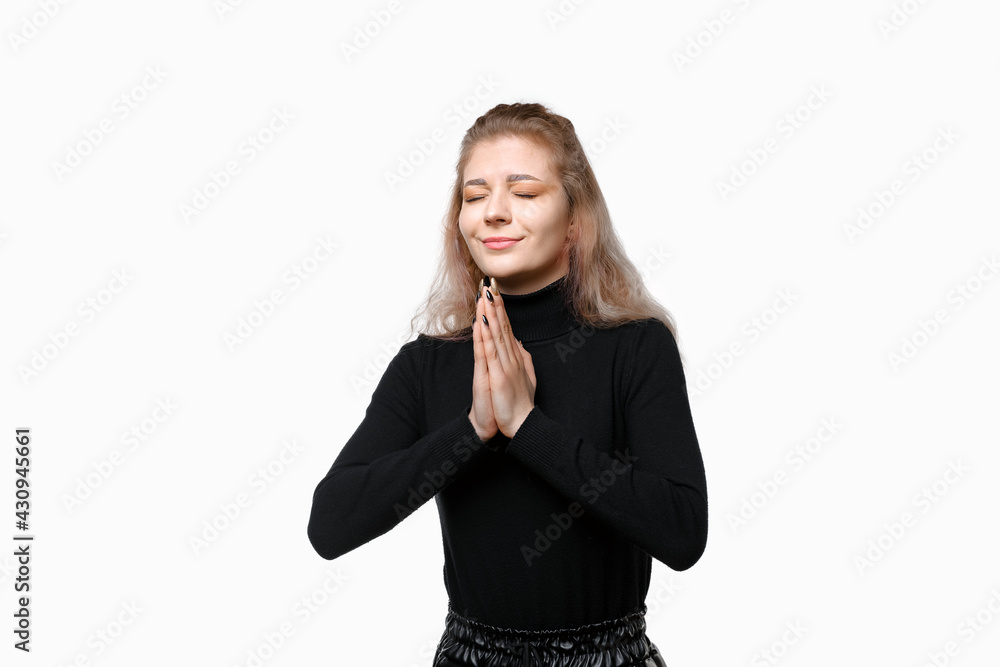 Young woman praying with closed eyes pleading everything be okay, concerned for someone, standing over white background Young woman praying with closed eyes pleading everything be okay, concerned for someone, standing over white background