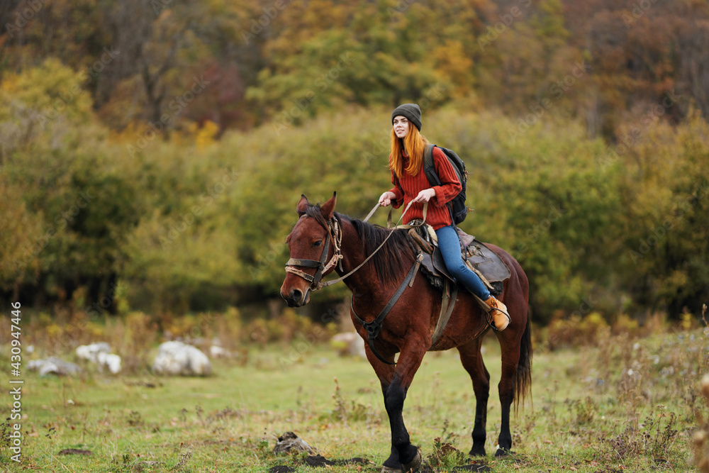 woman hiker with a backpack rides a horse in the mountains nature friendship