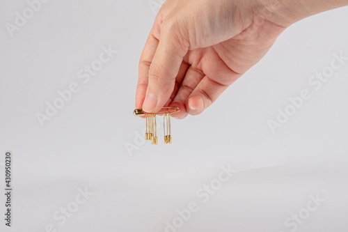 hand holding safety pins Isolated on white background