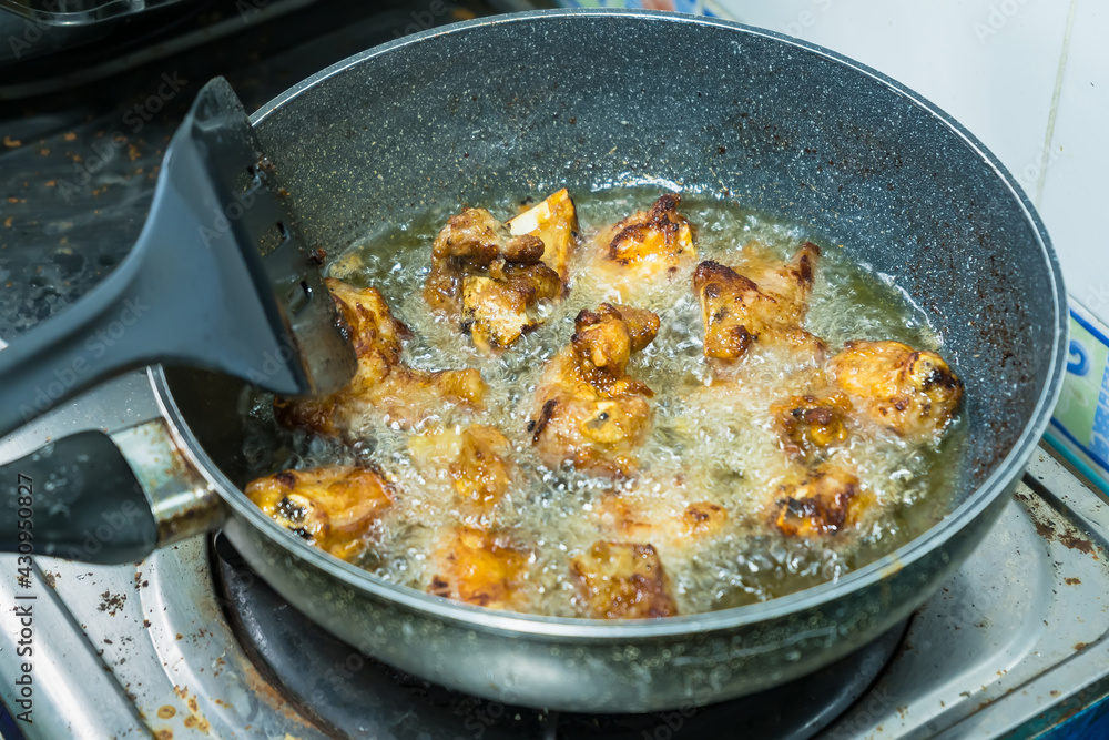 Fried pork bones in a pan on the gas stove in the kitchen Fried pork bones in a pan on the gas stove in the kitchen