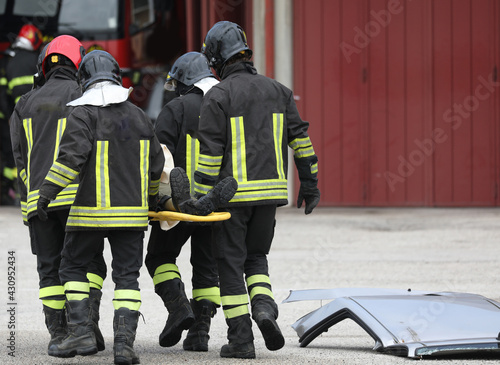 firefighters while rescuing the injured with a stretcher after the road accident