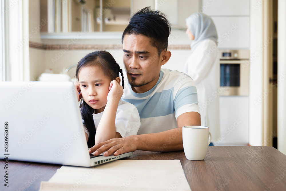 Father or husband working from home while child is sitting on his lap
