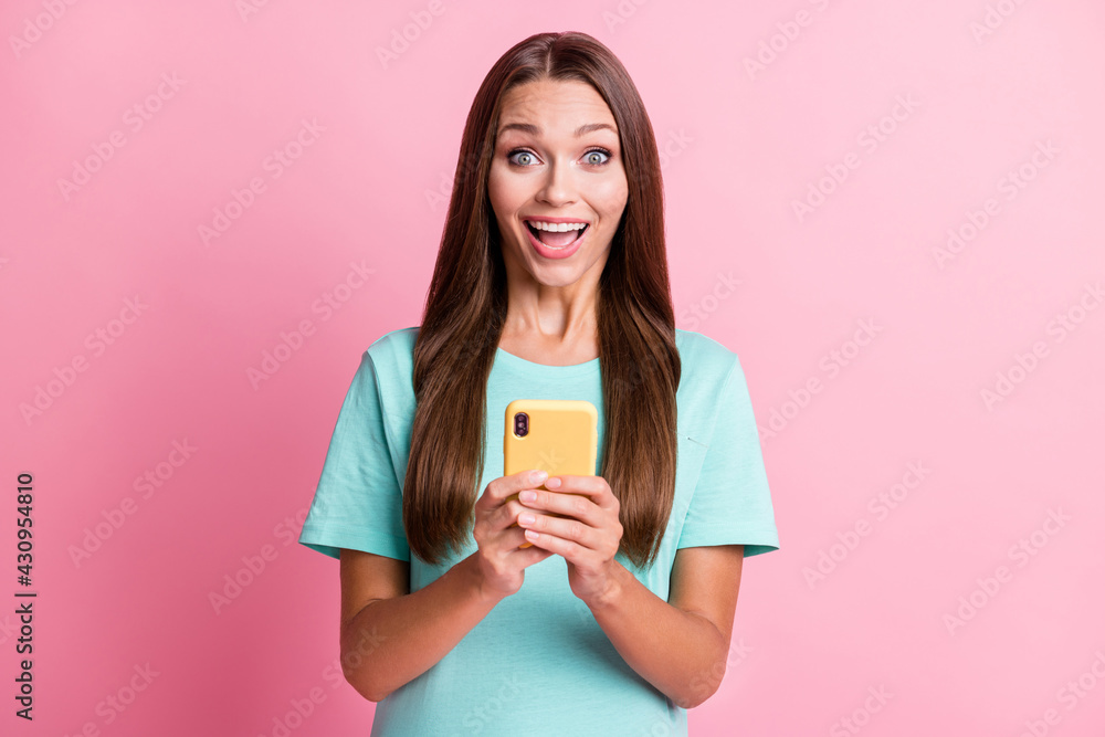 Photo portrait of surprized impressed woman keeping cellphone staring opened mouth isolated on pastel pink color background Photo portrait of surprized impressed woman keeping cellphone staring opened mouth isolated on pastel pink color background
